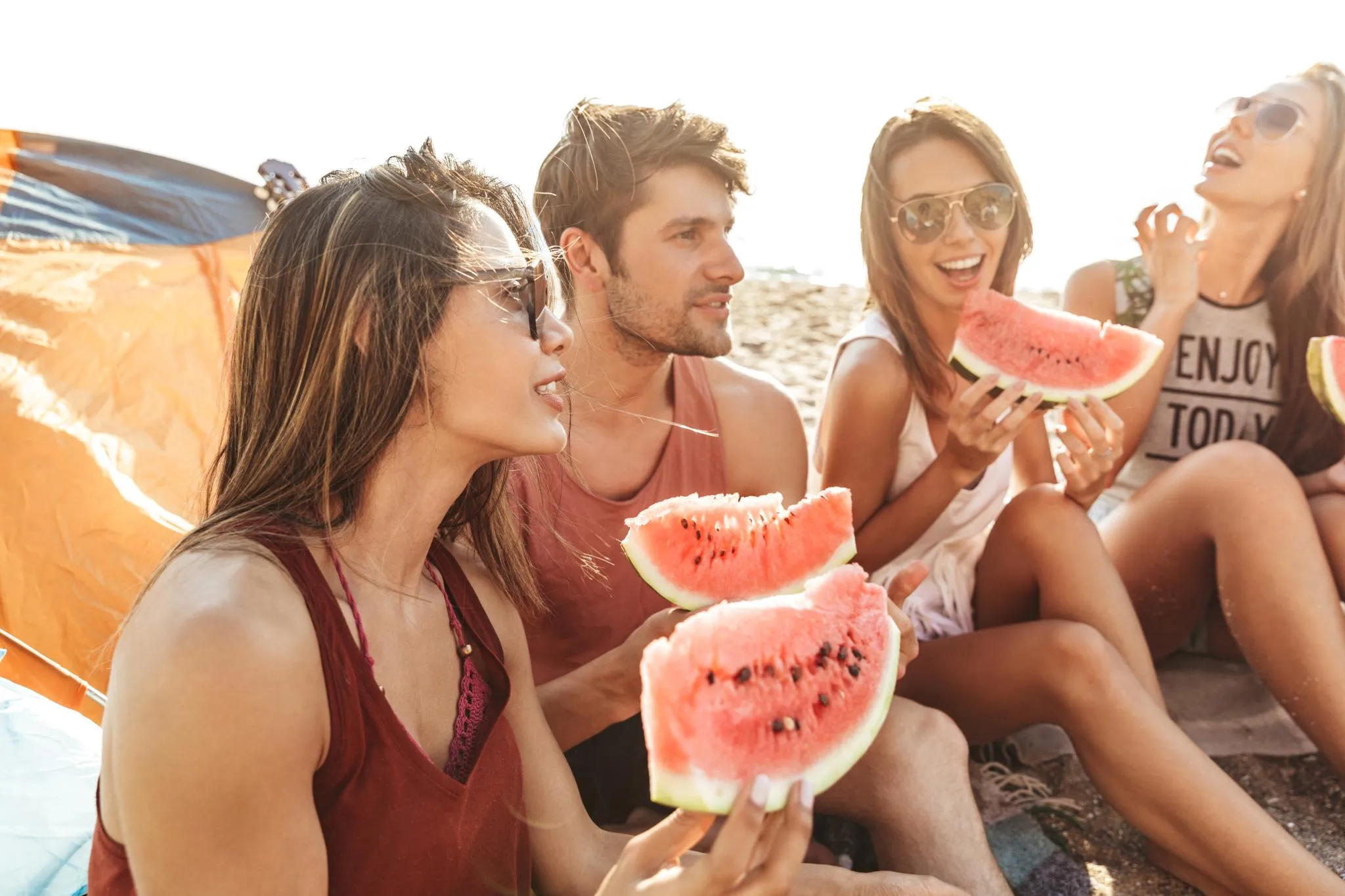 grupo de personas comiendo sandia y sonriend